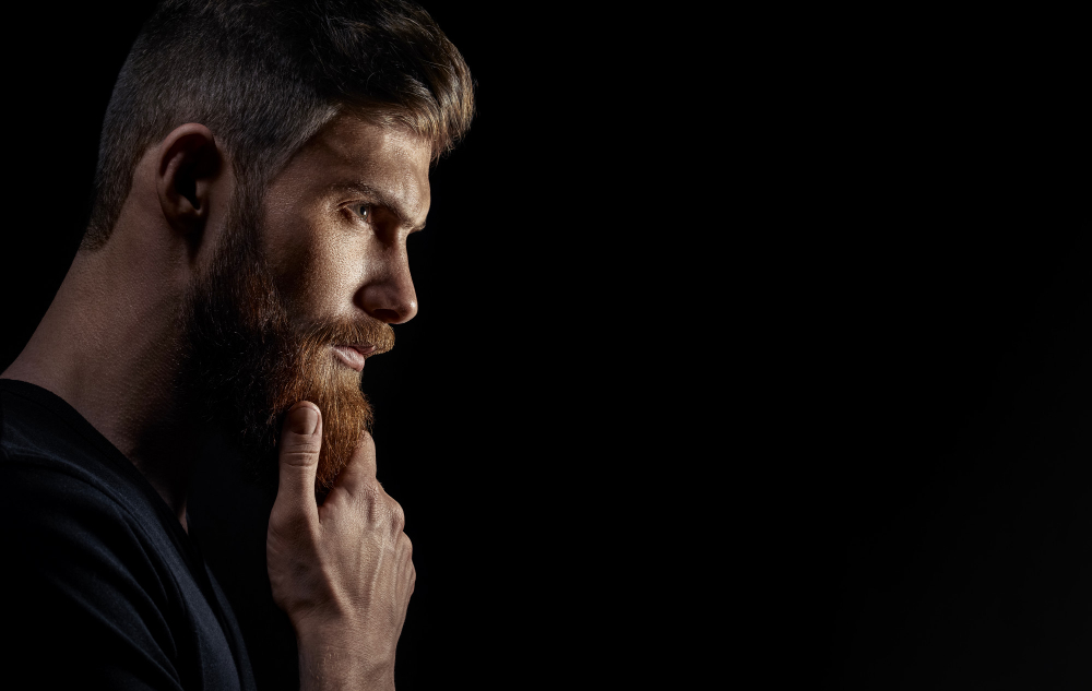 attractive-pensive-young-bearded-man-looks-into-distance